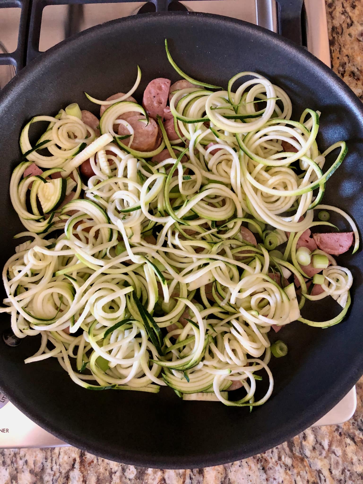 zoodles in skillet with sausage