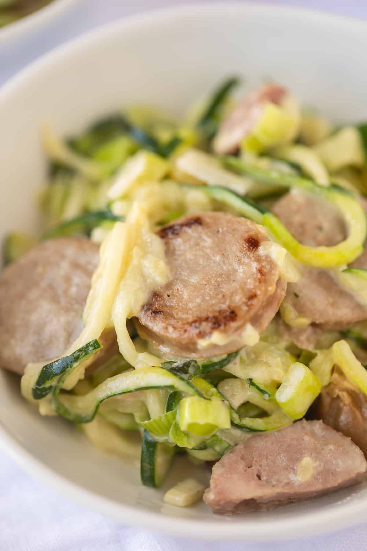 bowl of zoodles with sausage and tahini sauce