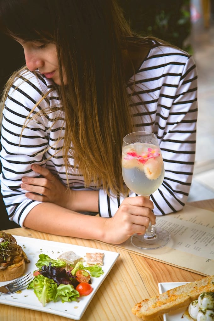 woman eating lunch with a fruit infused water. 