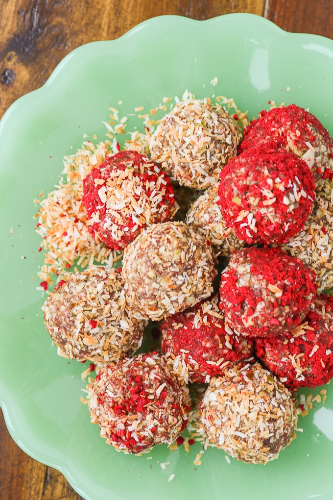 coconut raspberry date balls on a green plate