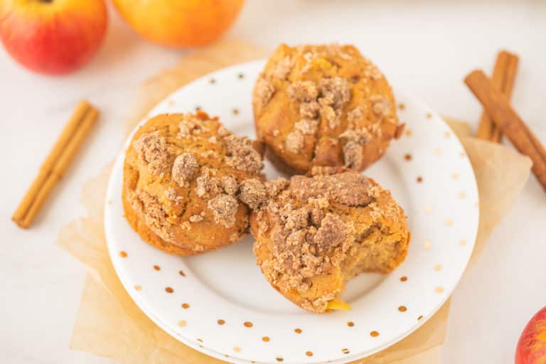 plate with three apple muffins on a table