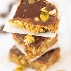 chocolate fig bars stacked on top of each other with parchment paper between each one