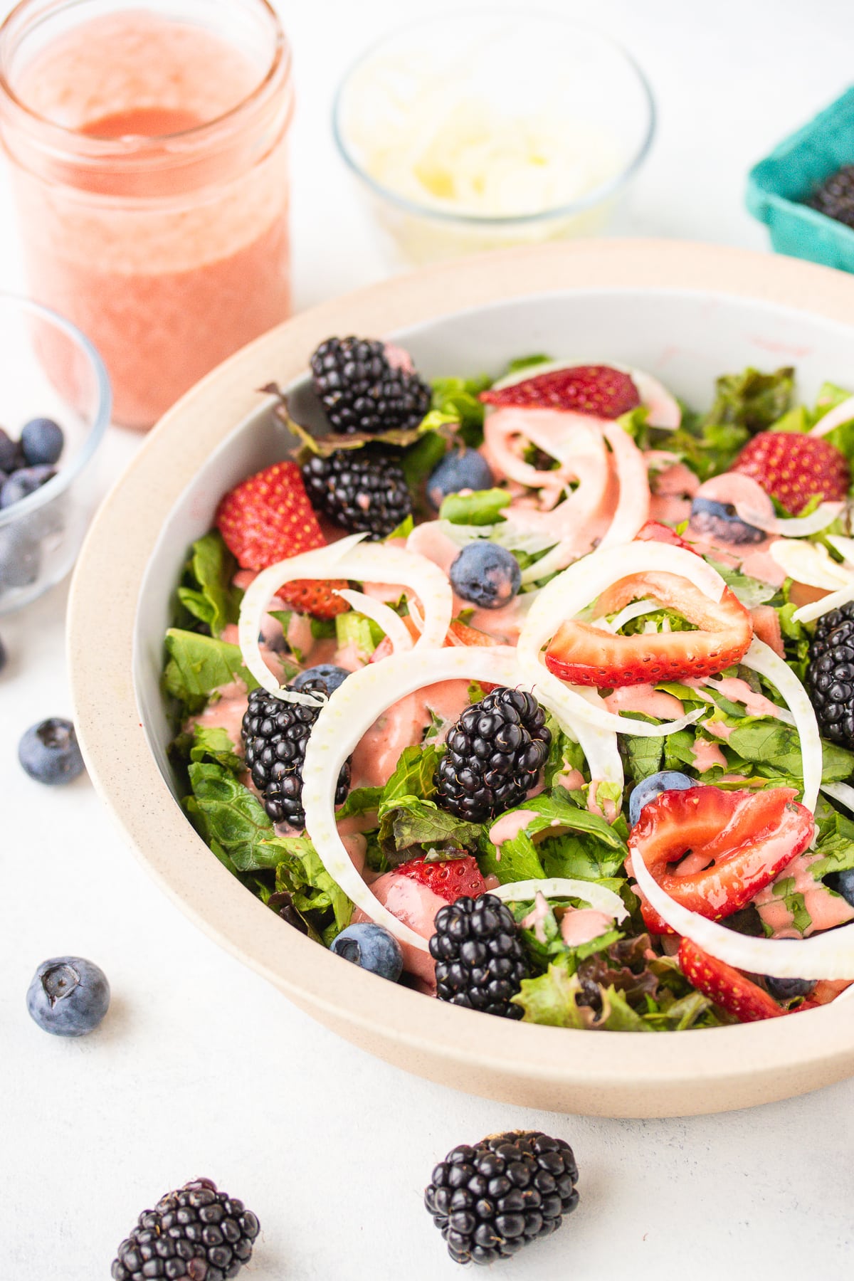 Summer Salad with Creamy Strawberry Salad Dressing in a bowl with berries, greens and fennel.
