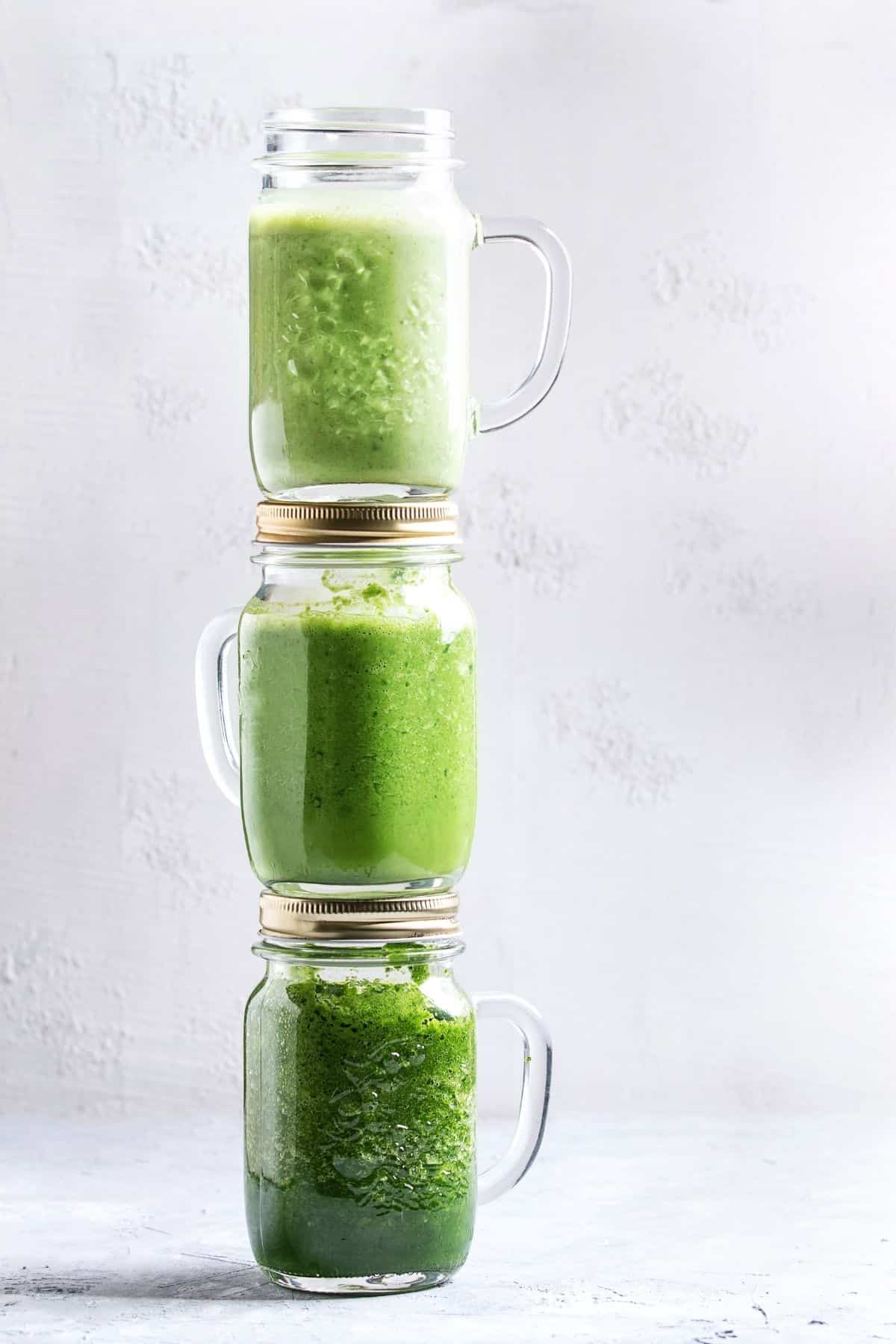 three jars of green smoothies stack on top of each other