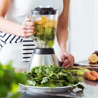 woman making a green smoothie