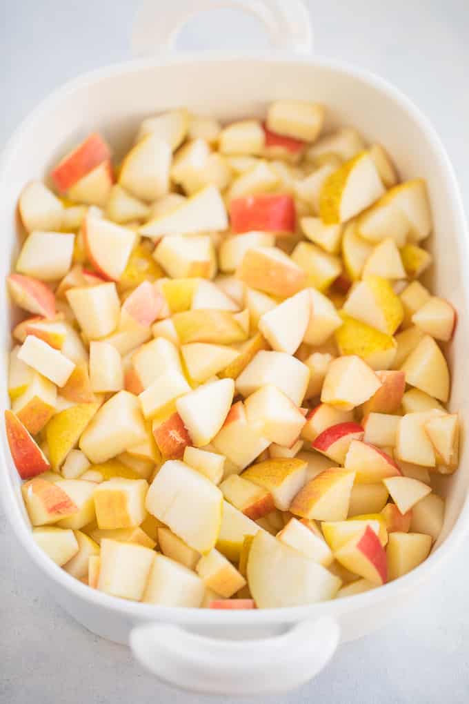chopped apples and pears in a white baking dish