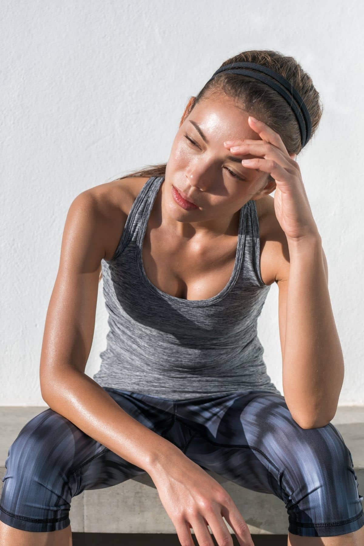 skinny woman in exercise clothes tired