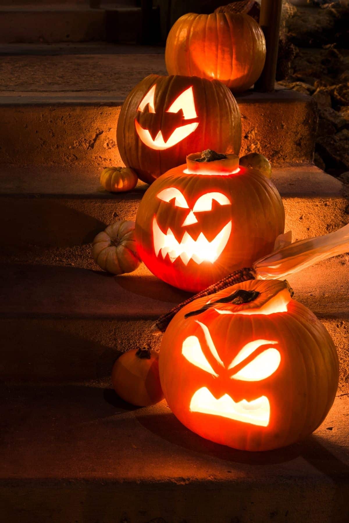 three jack o'lanterns on a porch.