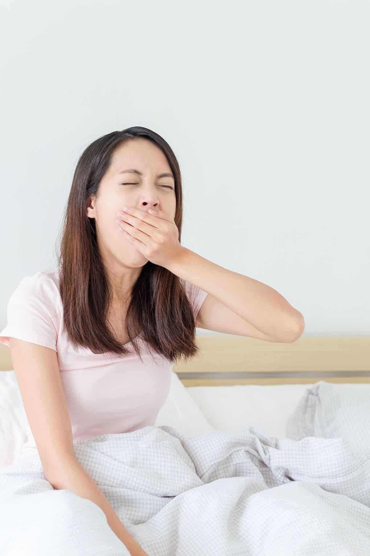 woman in bed yawning