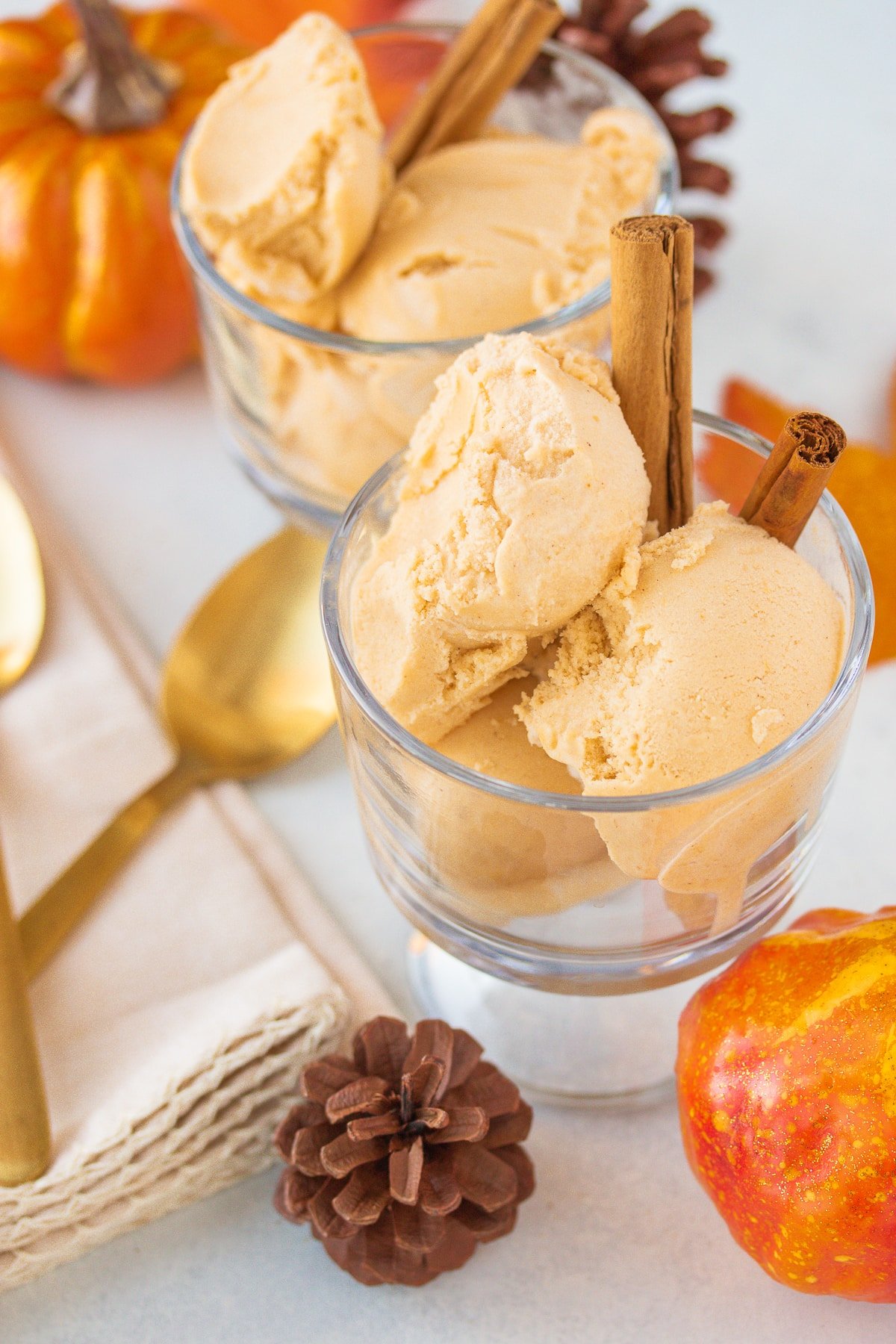 two bowls of pumpkin ice cream with cinnamon sticks.