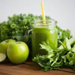green juice on table with vegetables