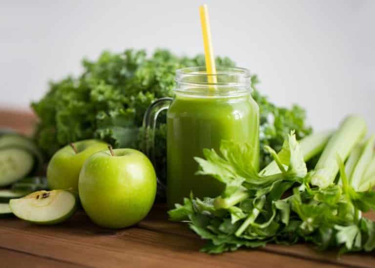 green juice on table with vegetables