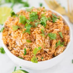 spanish rice in a bowl with two gold forks