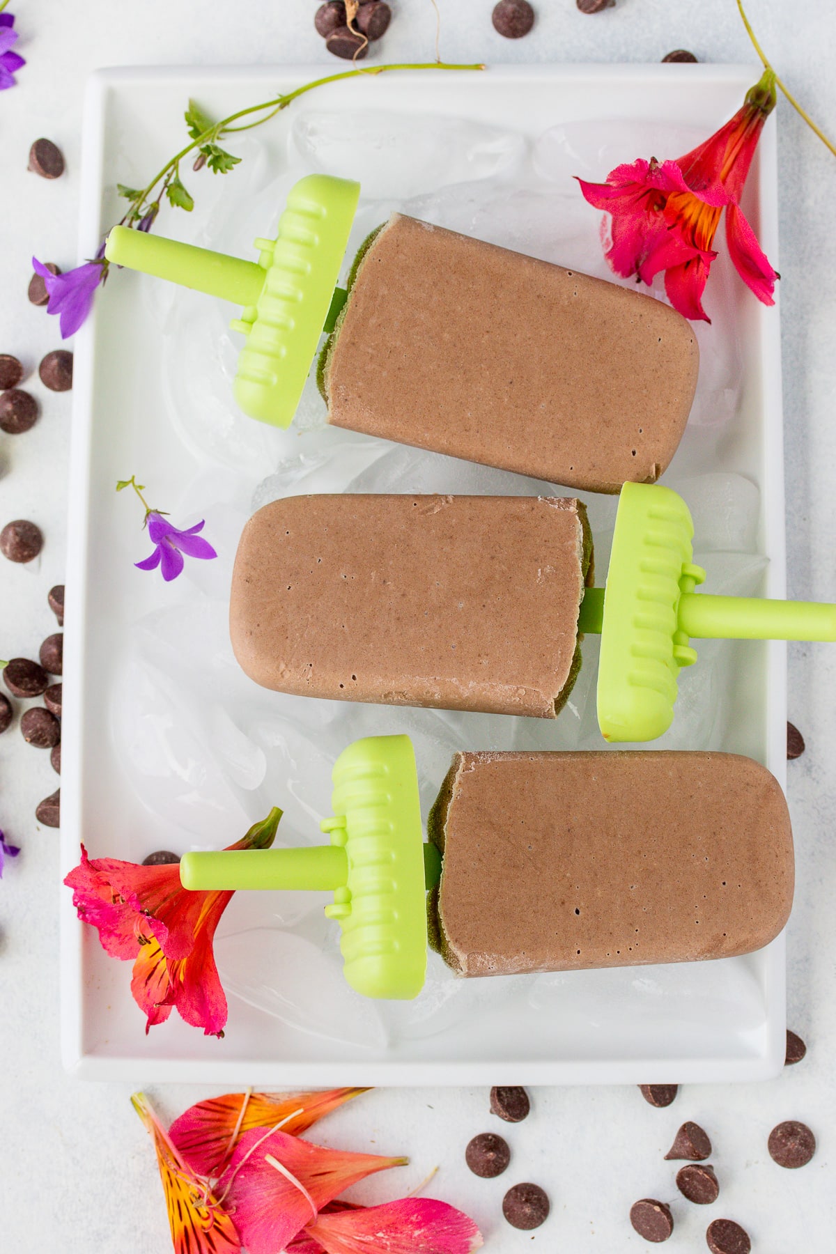homemade vegan fudgesicles on a tray with ice