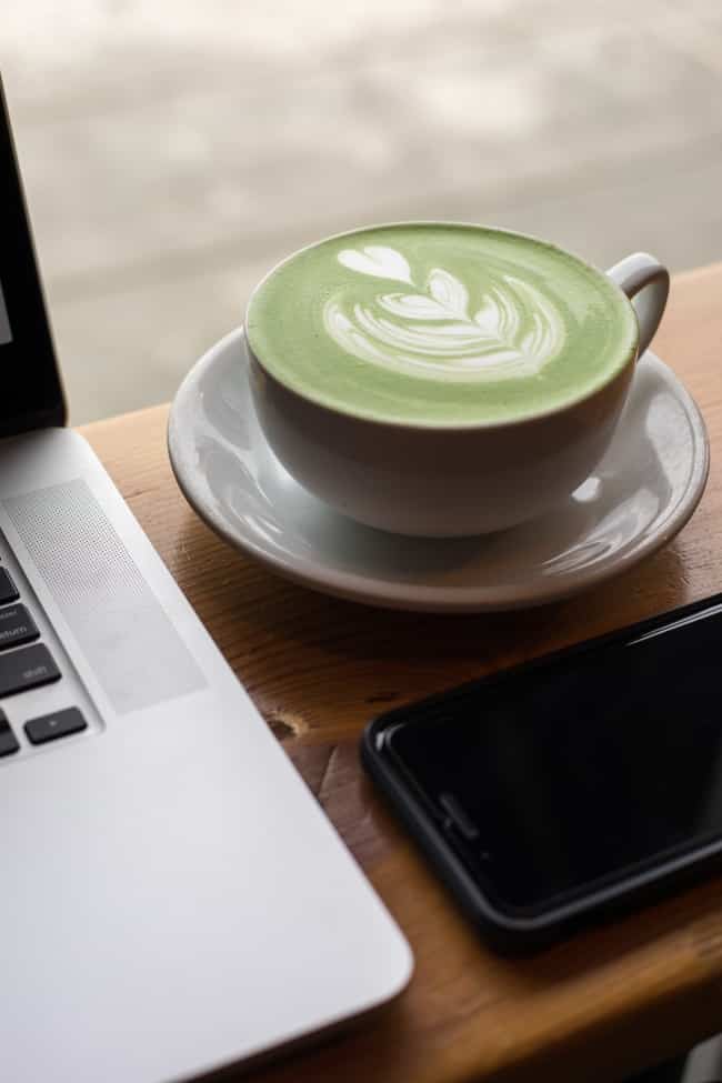 Matcha latte beside a computer
