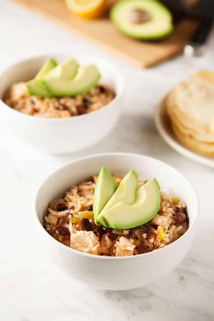 Delicious Mexican rice bowls topped with creamy avocado.