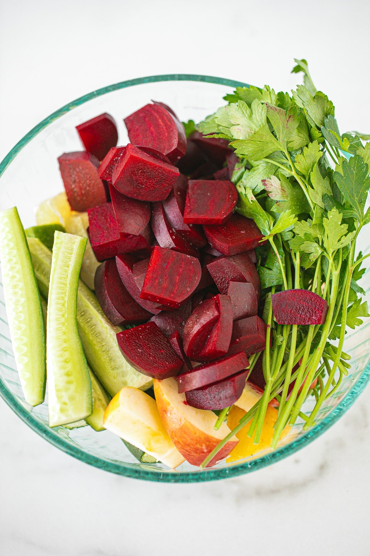 chopped beets and other vegetables in a bowl ready to be juiced.