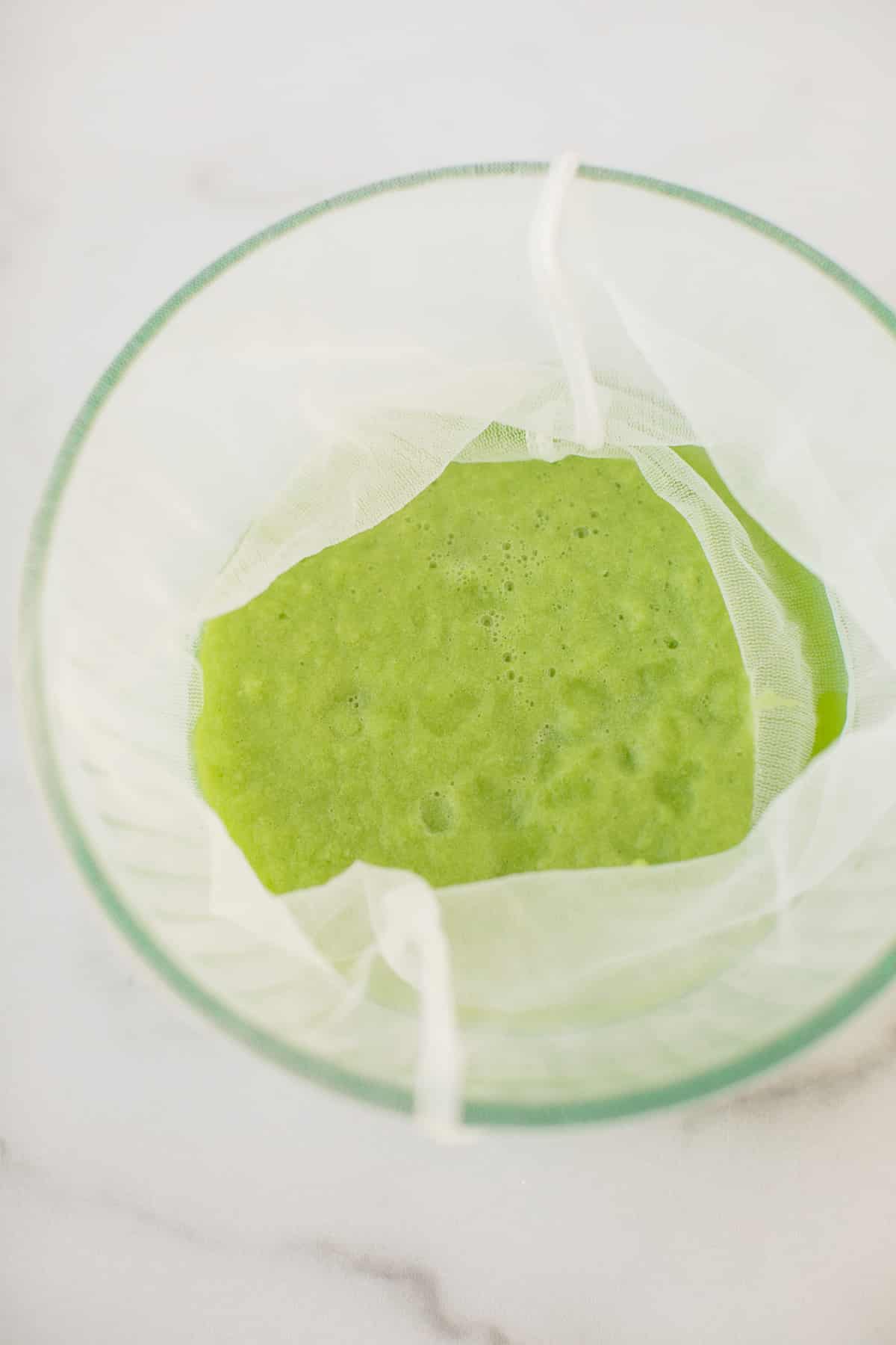 blended celery juice in a nut milk bag