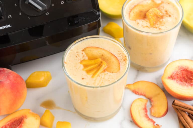 Mango Peach Smoothie glass on table.