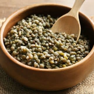 cooked green lentils in bowl with spoon
