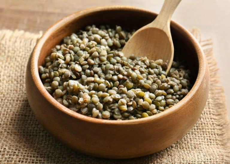 cooked green lentils in bowl with spoon