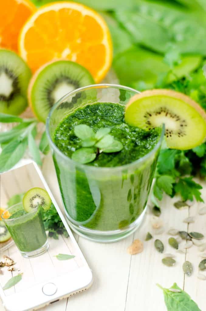 green smoothie with kiwi on table.