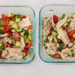 two meal prep containers with salad and chicken