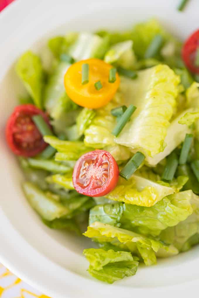 romaine salad with tomatoes in a white bowl