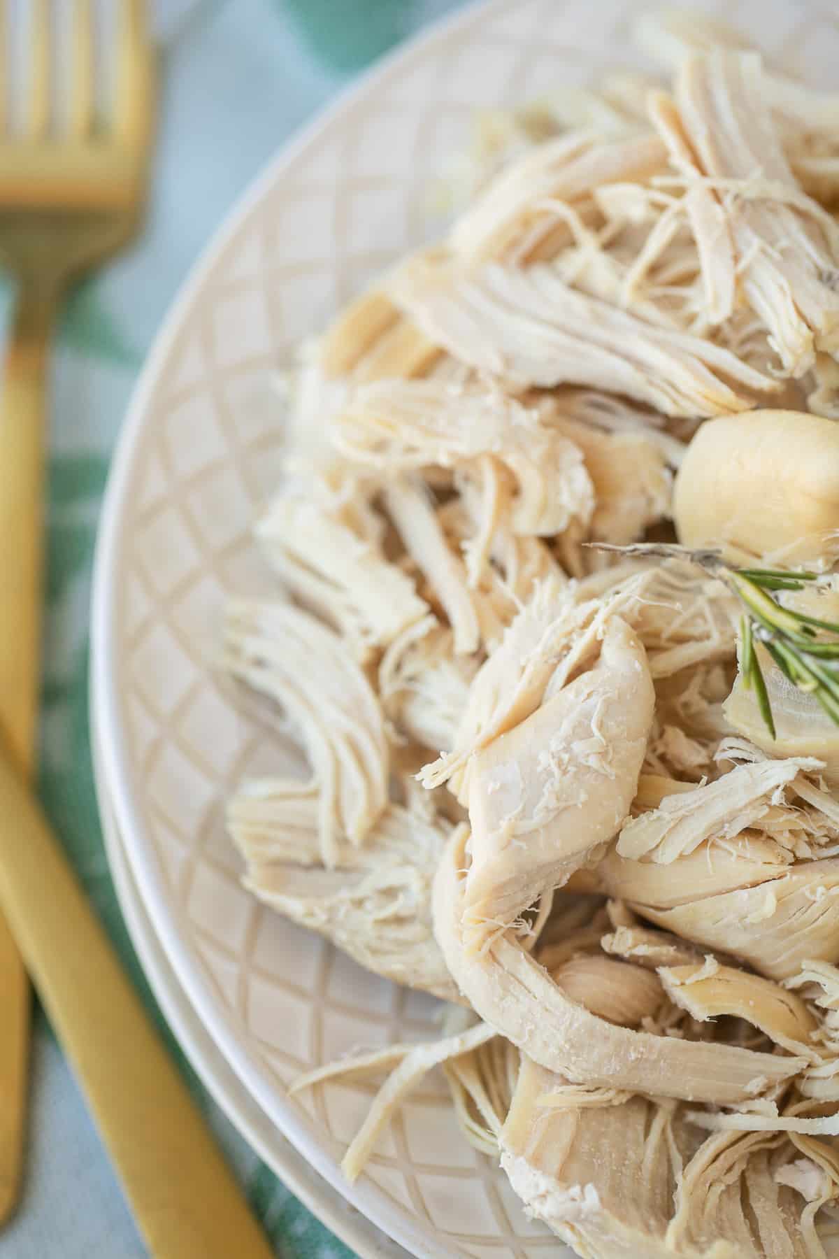 shredded chicken on a plate with a gold fork