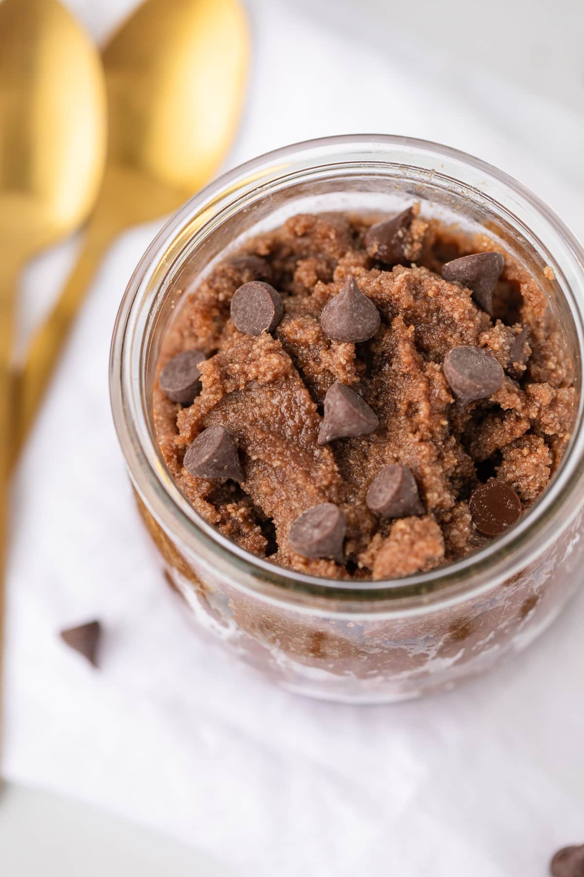 brownie batter in a jar with two gold spoons