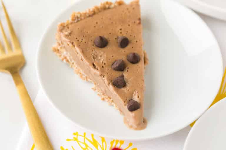 slice of vegan peanut butter pie on a plate with a gold fork.