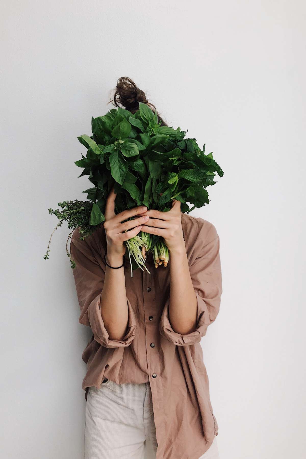 woman hiding behind greens