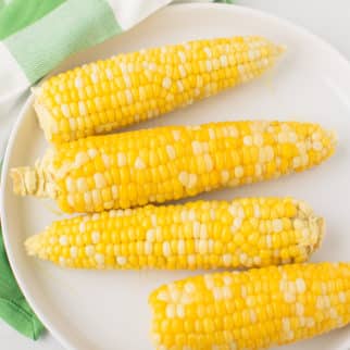 plate of corn on the cob on top of a green napkin.