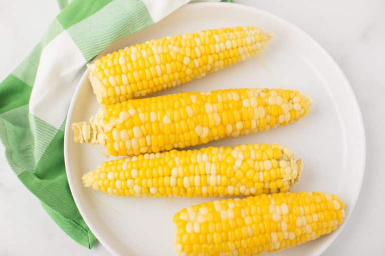 plate of corn on the cob on top of a green napkin