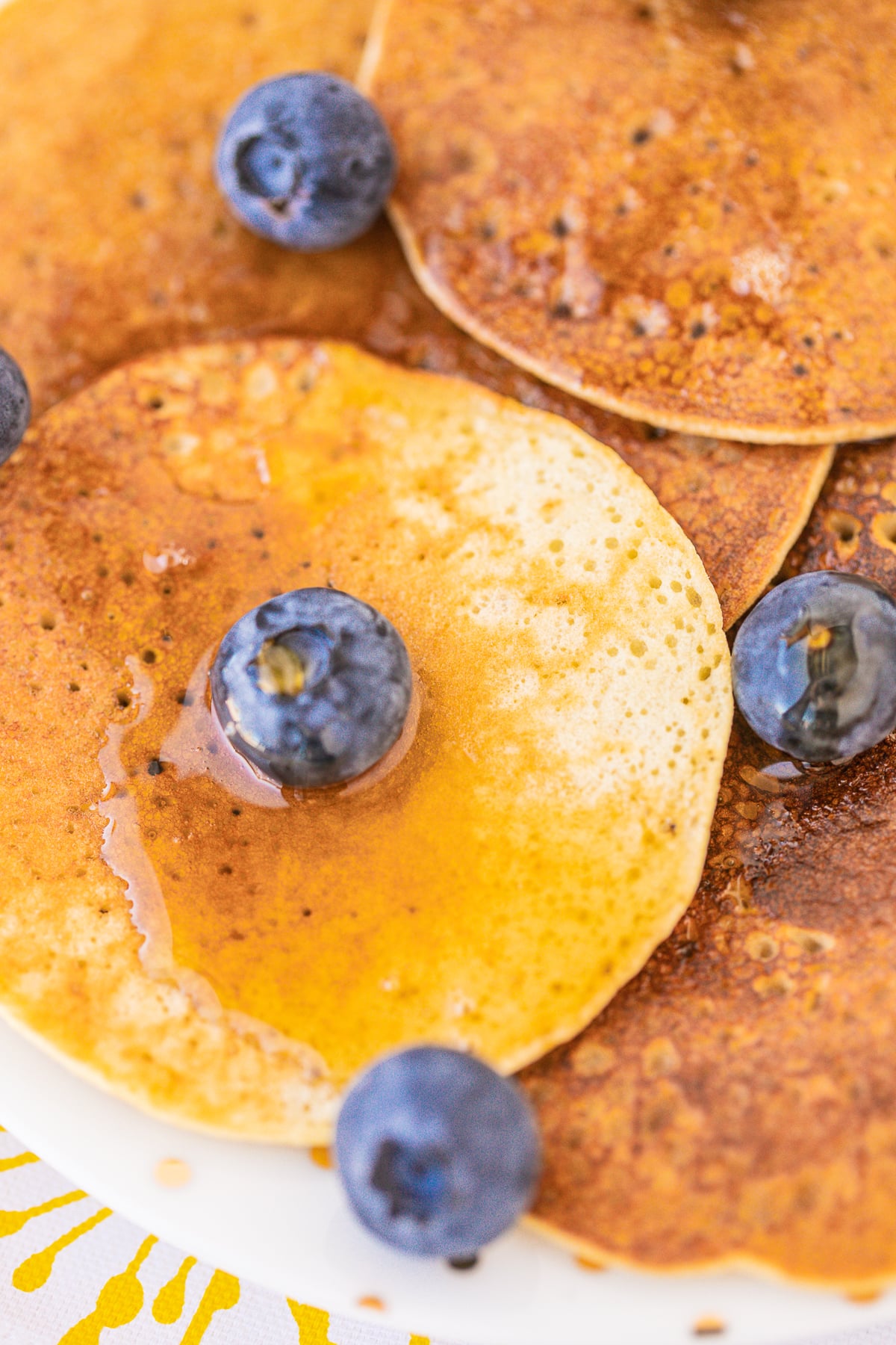 pancakes on a plate up close with blueberries on top