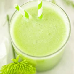 honeydew smoothie in a glass with a straw