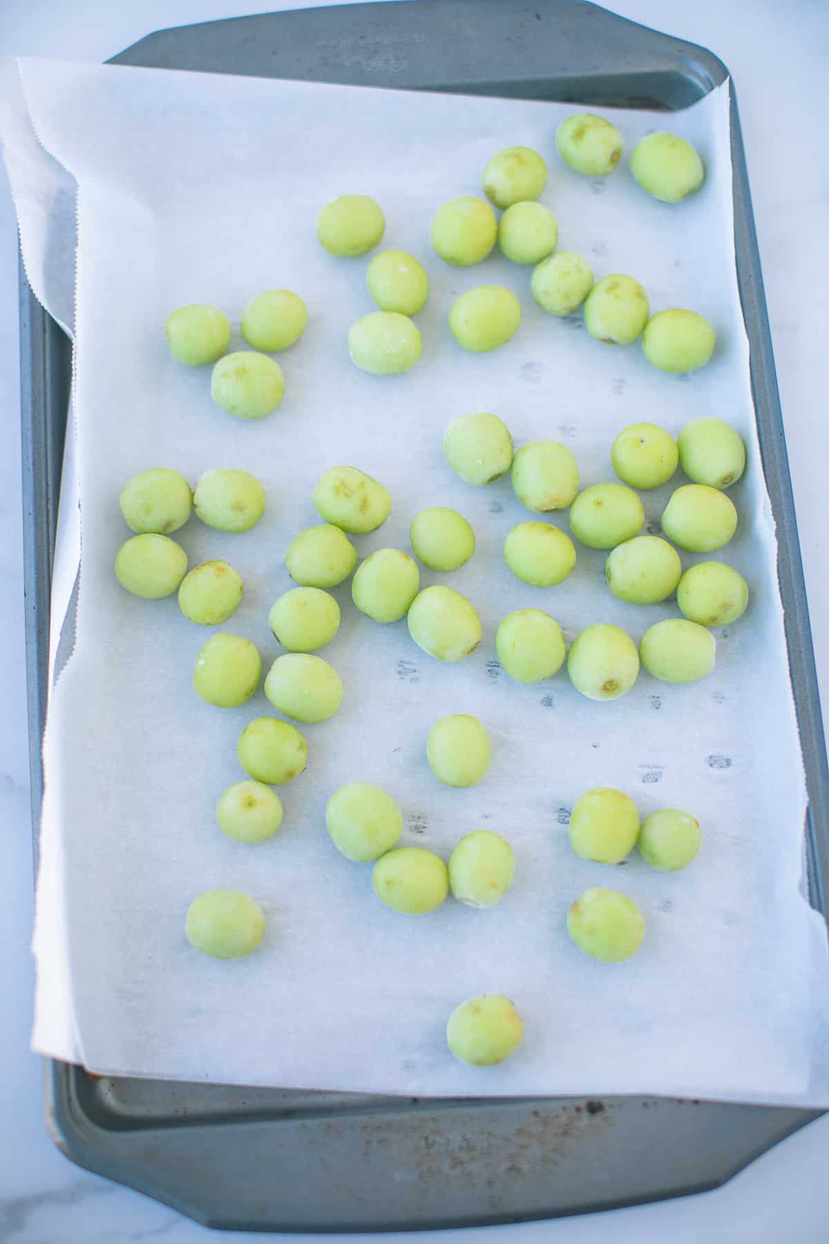 frozen grapes on a baking sheet.