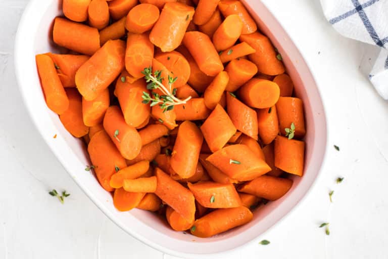 bowl with cooked carrots topped with fresh thyme