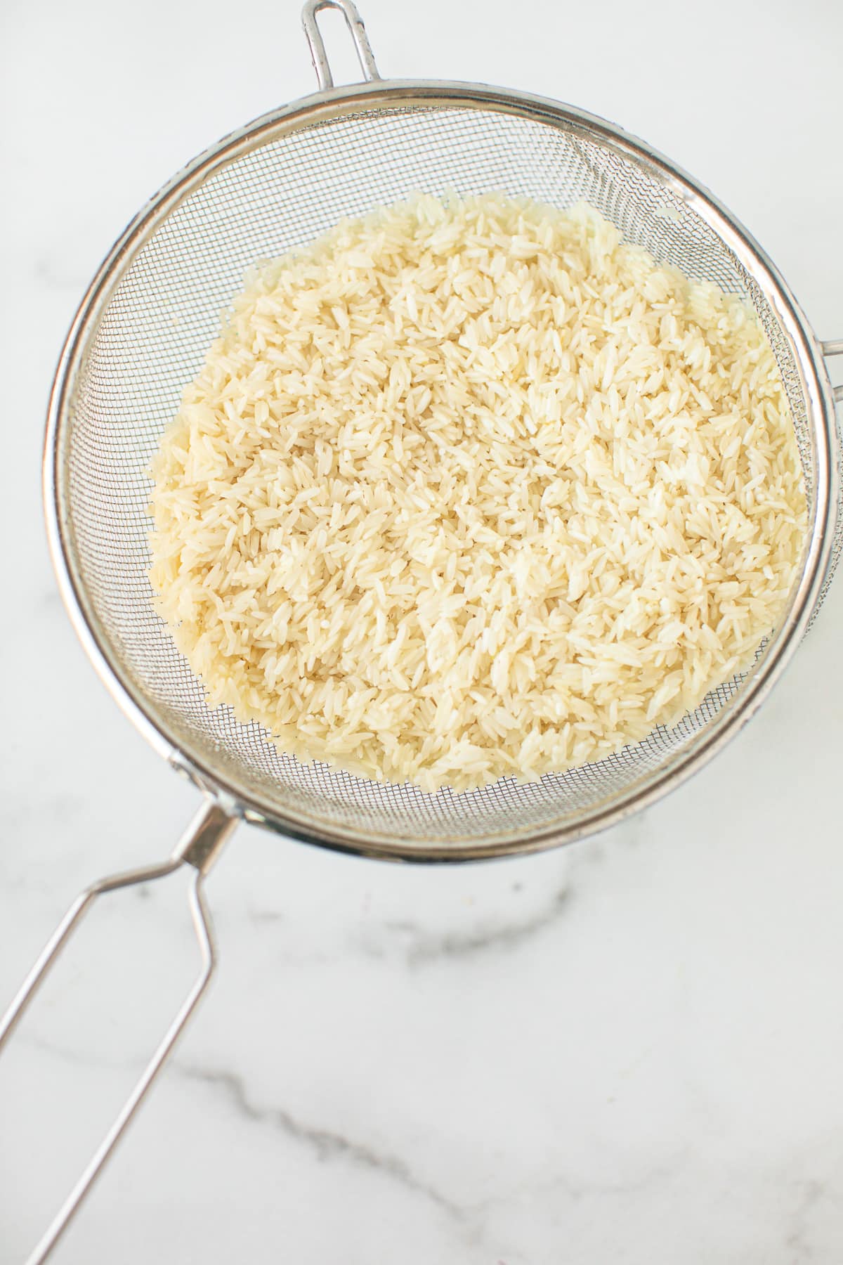 white rice rinsed in a fine mesh colander