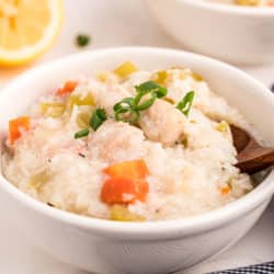 chicken rice soup with lemon in white bowl.