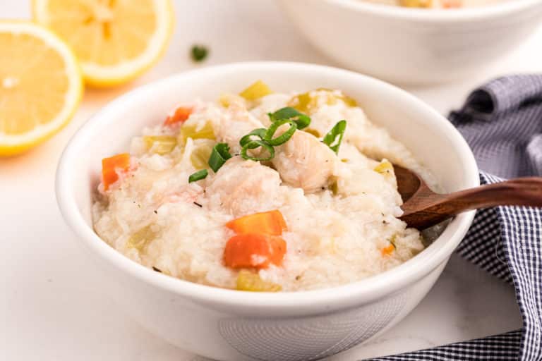chicken rice soup with lemon in white bowl.