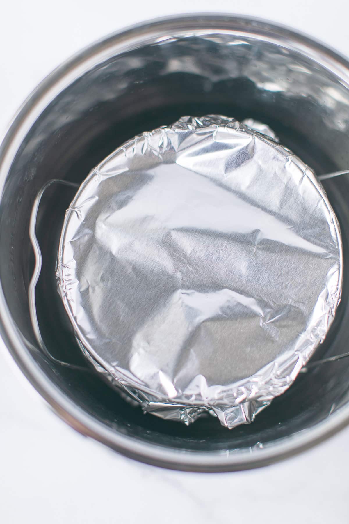 cake pan wrapped in foil inside the instant pot pressure cooker.