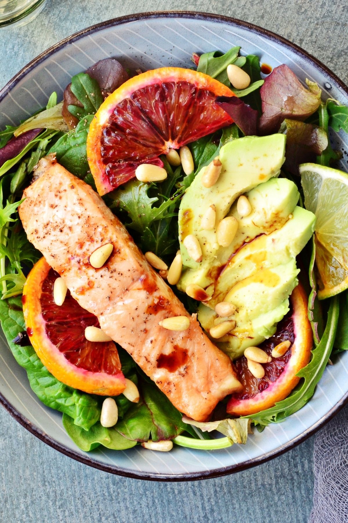 paleo meal with fruit, fish, avocado, and nuts.