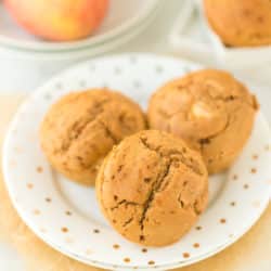 plate with three baked apple cider muffins on it