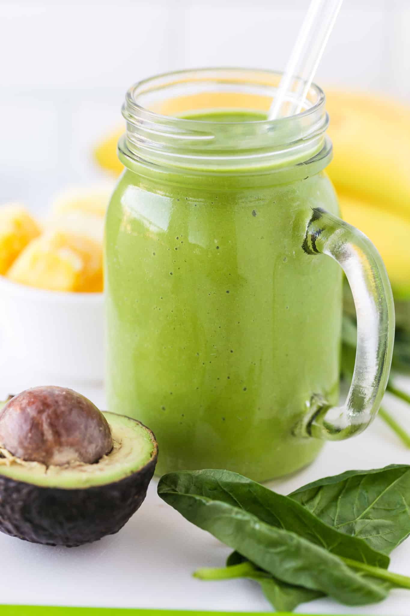 green liver detox smoothie served with a glass straw