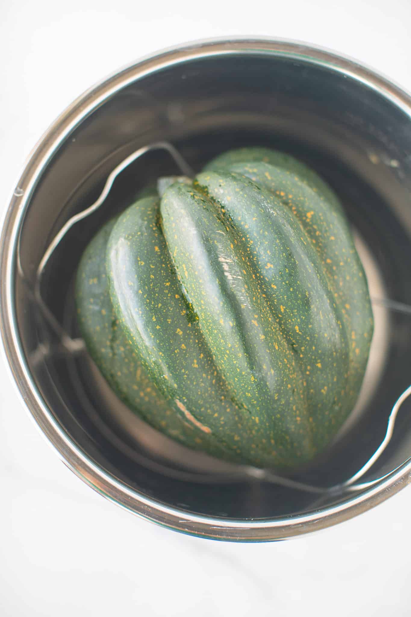 whole acorn squash inside of an instant pot.