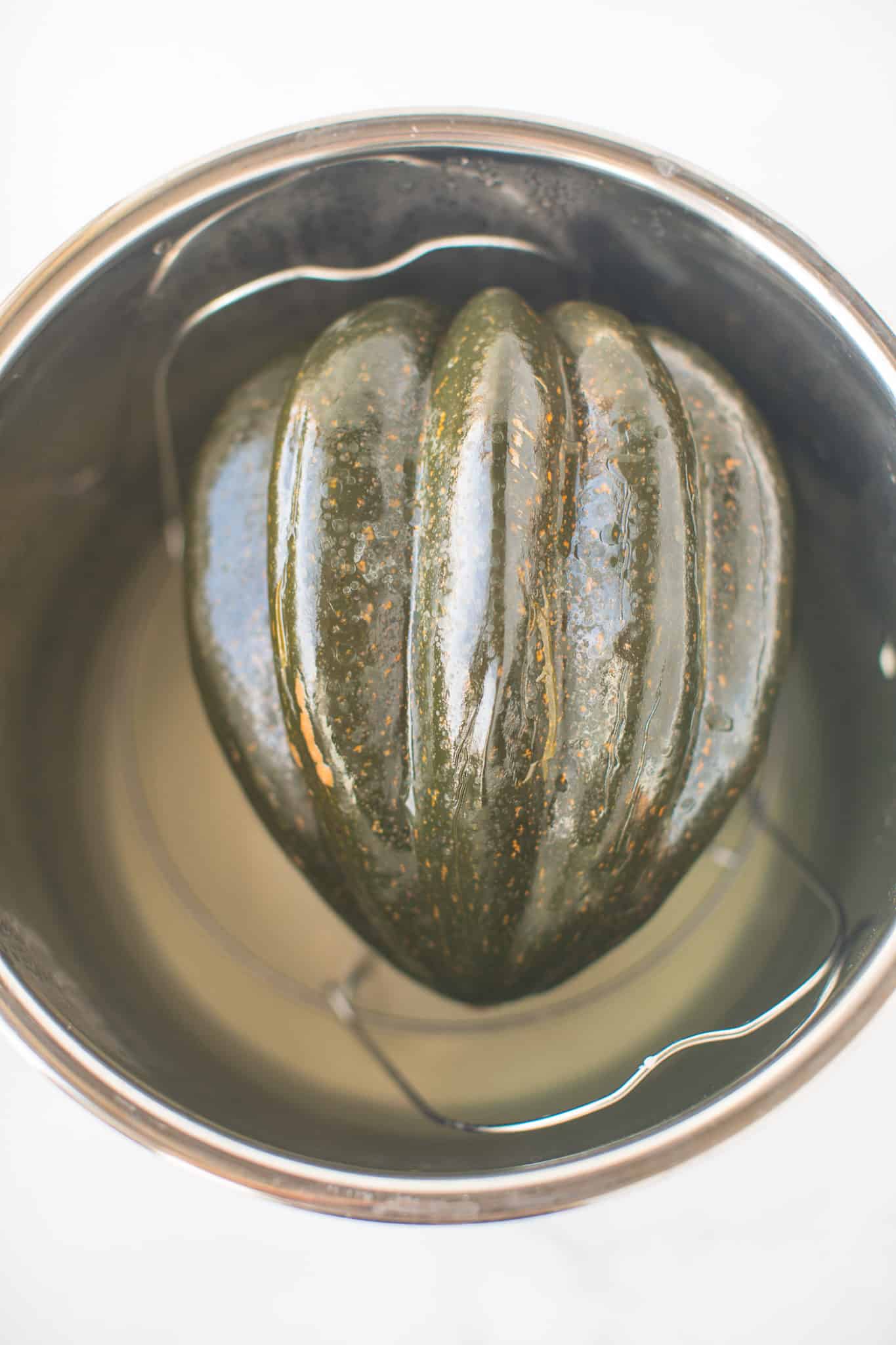 cooked whole acorn squash inside a pressure cooker.