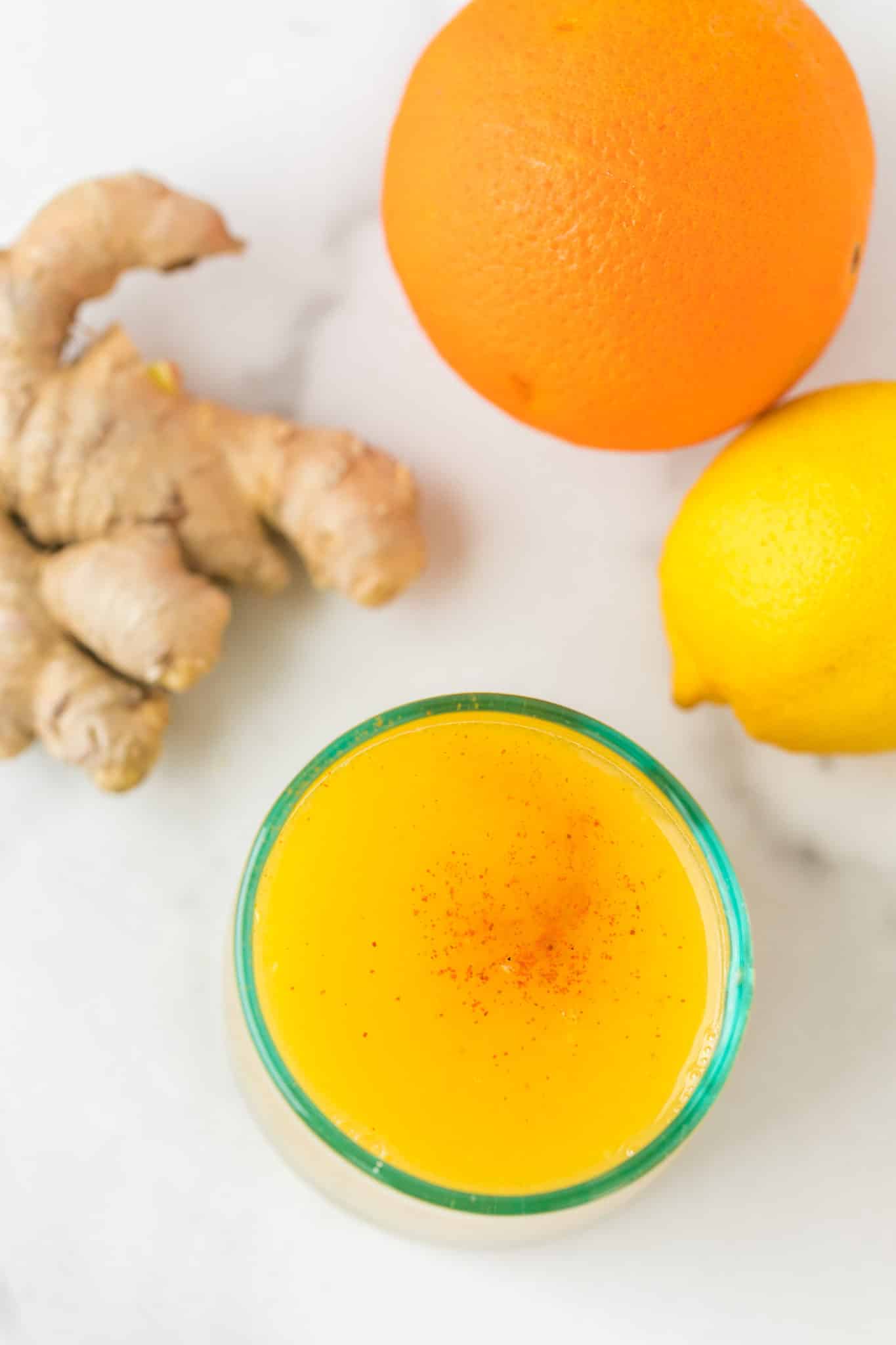 yellow juice served with a sprinkle of cayenne pepper on top