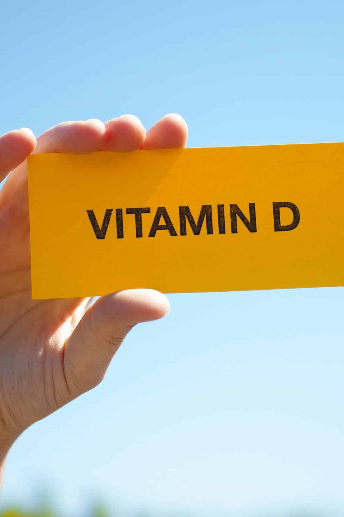 person holding a sign that says vitamin d.