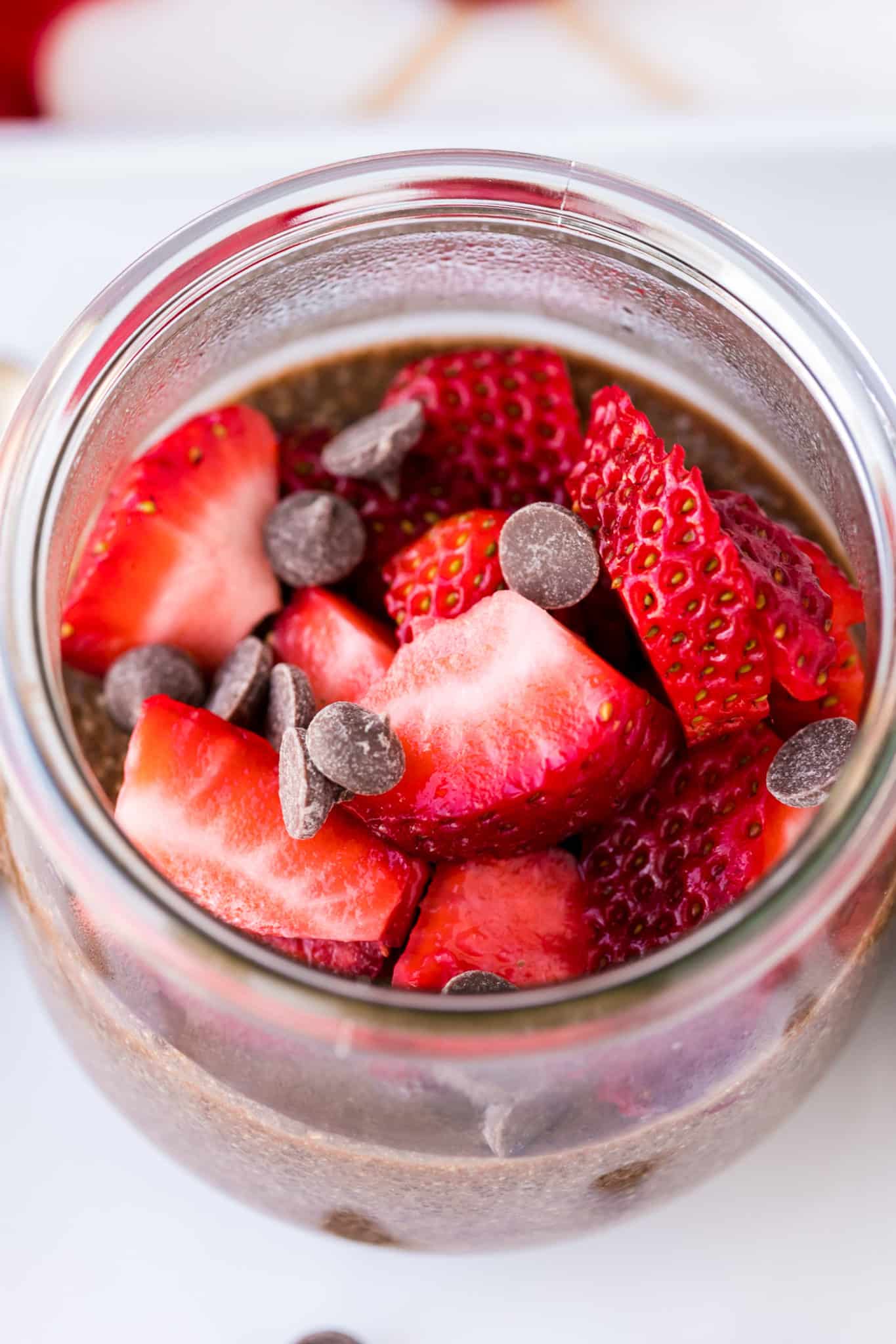 chocolate chia pudding topped with fresh strawberries and chocolate chips.